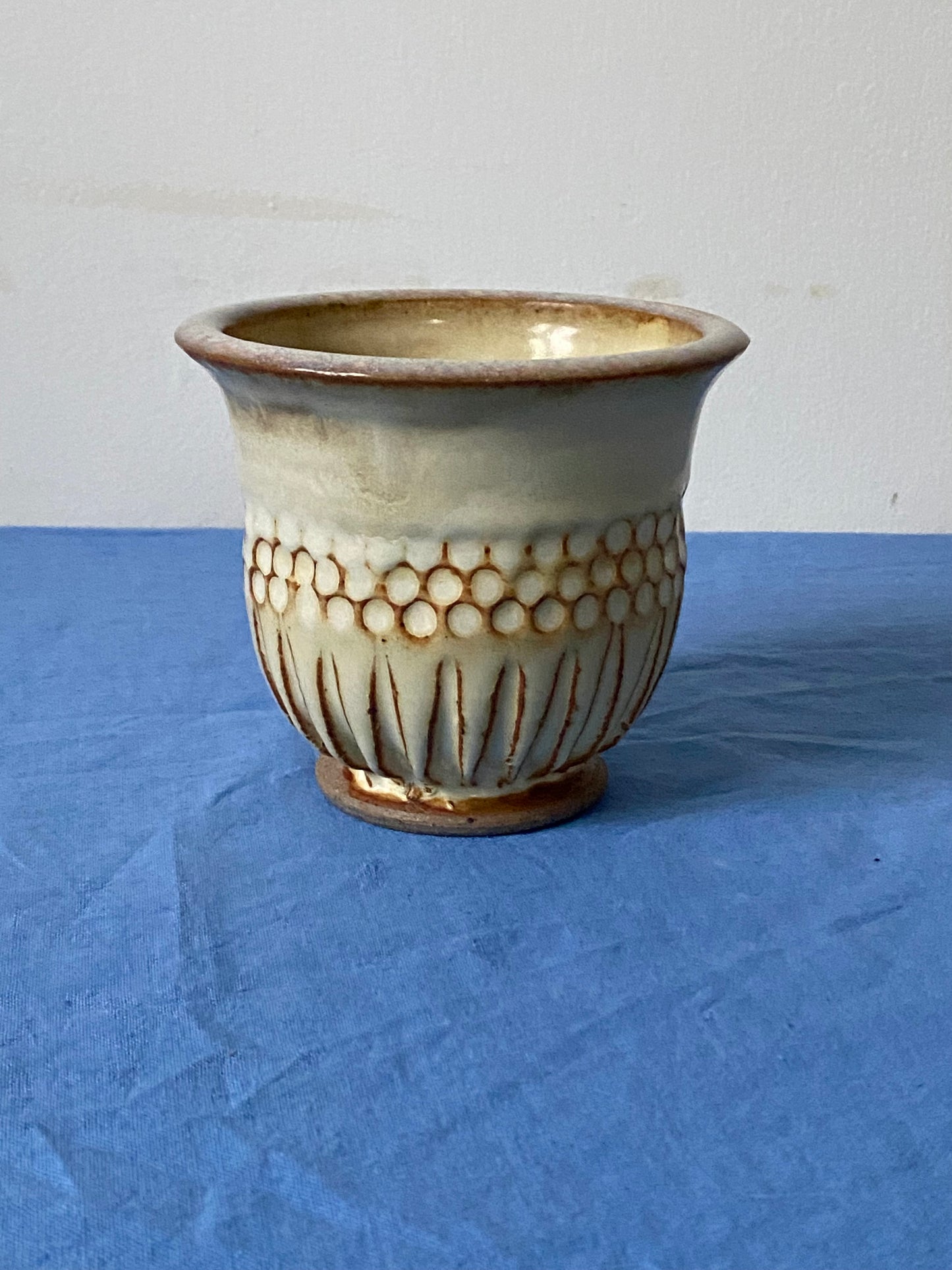 Cream tumbler with circular indentations