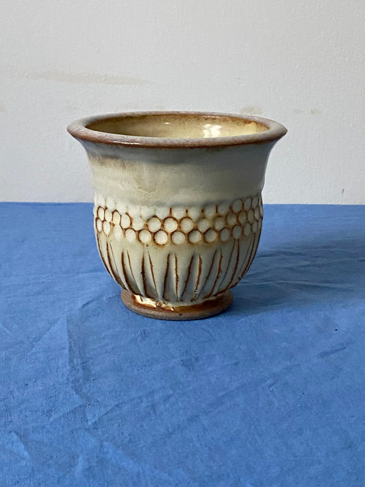 Cream tumbler with circular indentations